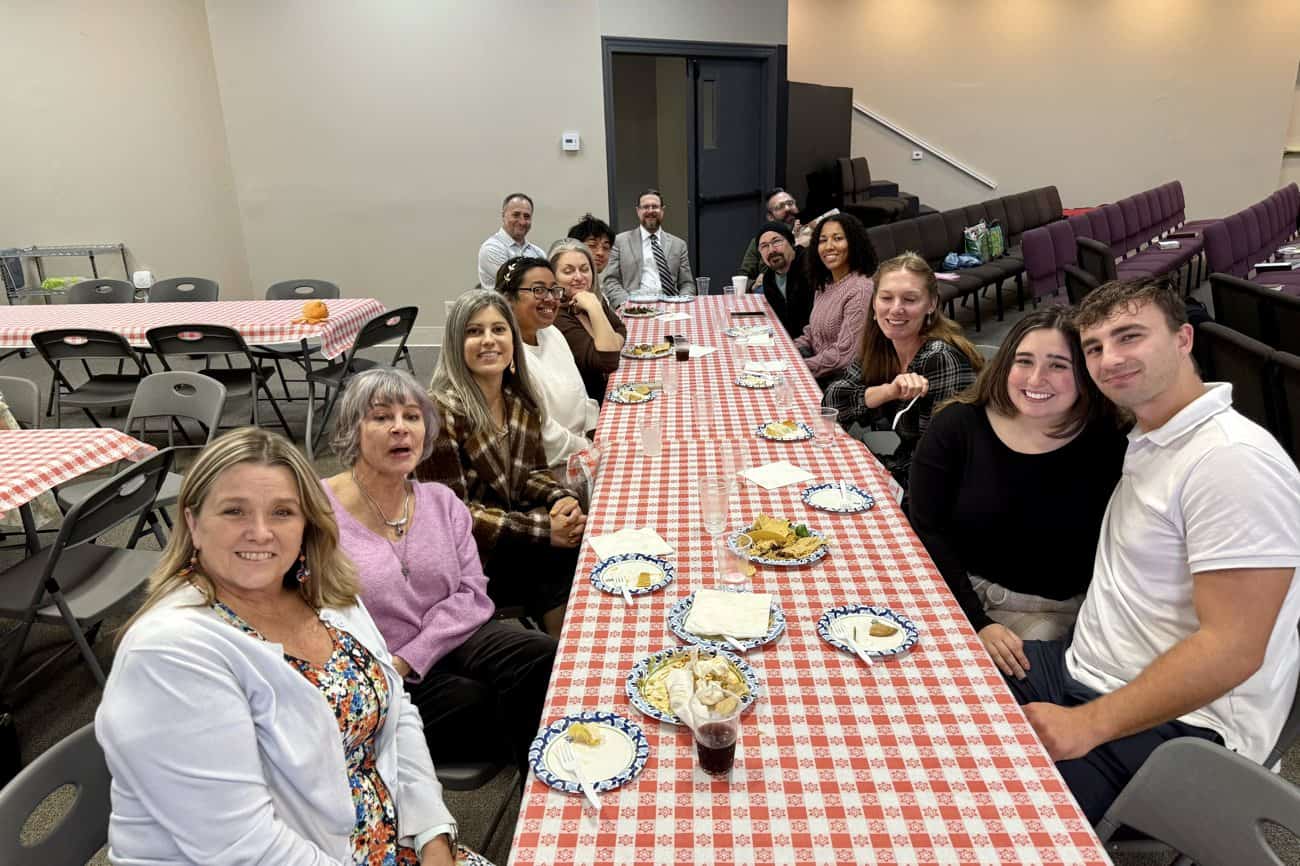 Church family gathered around the potluck table