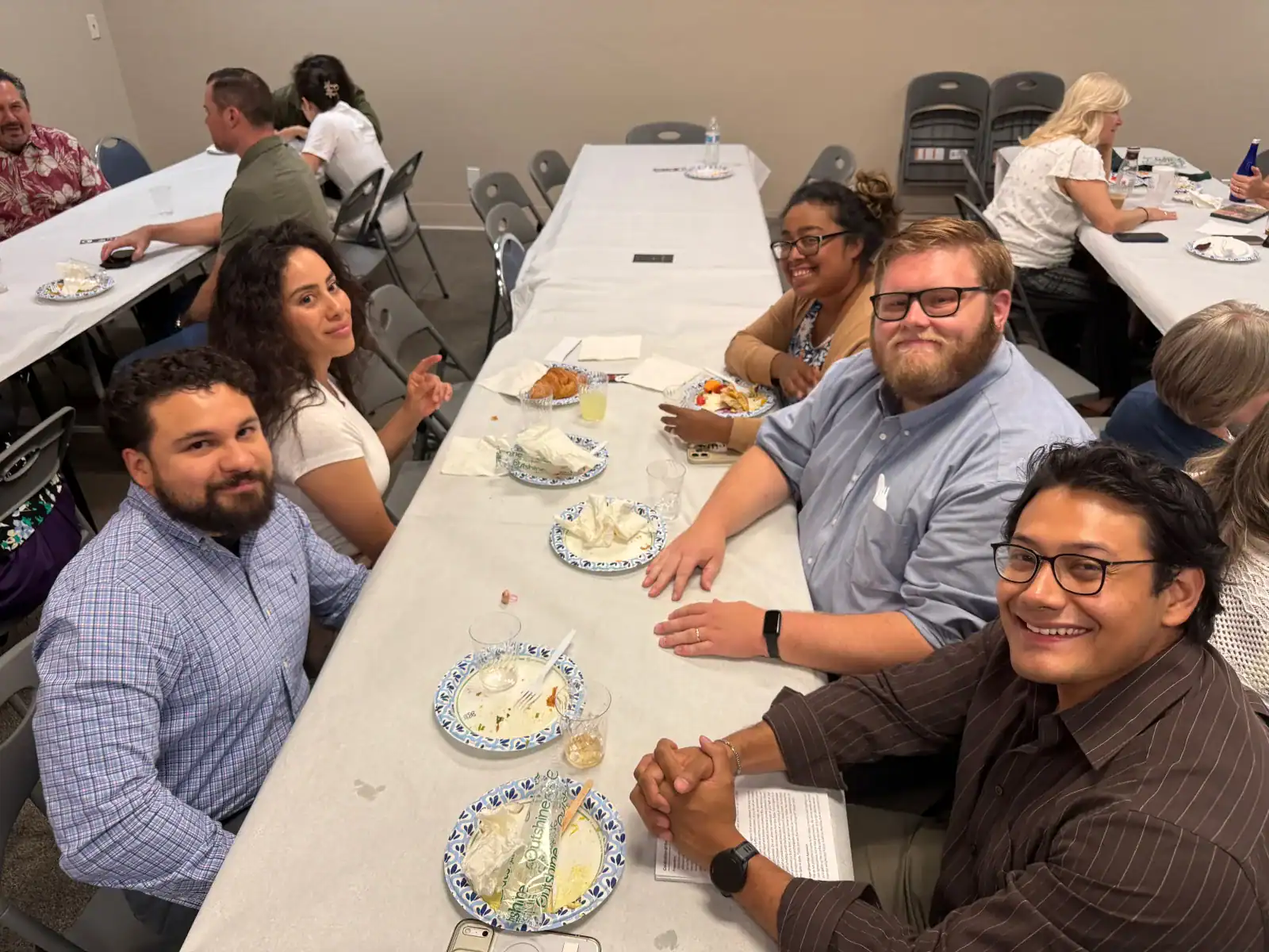 Members sharing fellowship around a table after worship